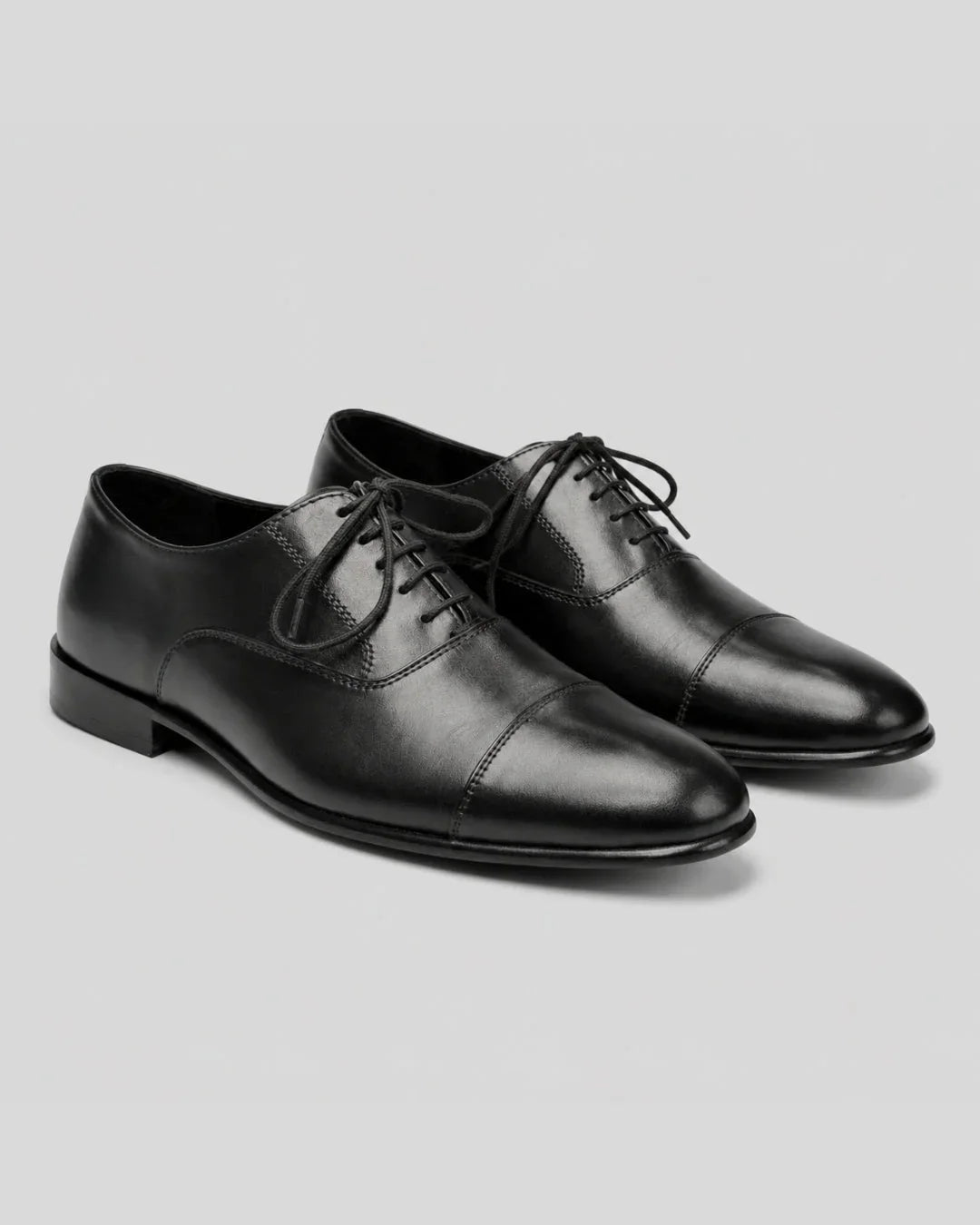 Black leather cap-toe dress shoes for men, handcrafted with classic design and sleek finish. Main image